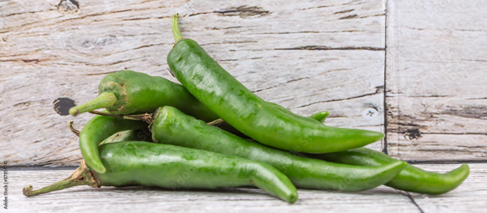 Chili peppers over wooden background Chili peppers over wooden background