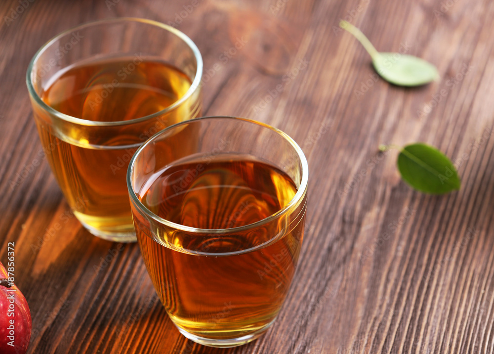 Glasses of apple juice on table close up Glasses of apple juice on table close up