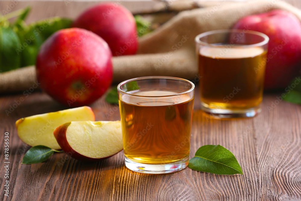 Glasses of apple juice and fruits on table close up Glasses of apple juice and fruits on table close up