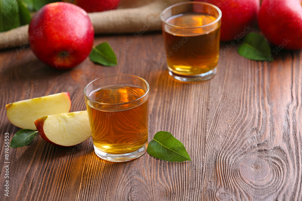 Glasses of apple juice and fruits on table close up Glasses of apple juice and fruits on table close up