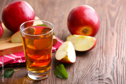 Glass of apple juice and fruits on table close up