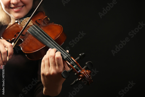 Photography Violinist playing violin on dark background