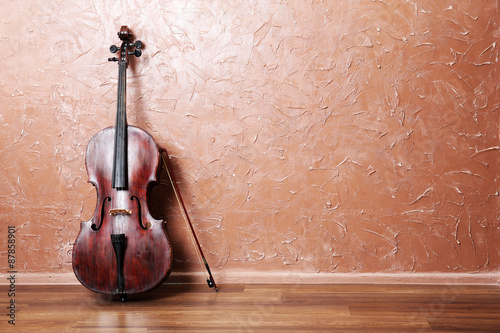 Photo Classical cello and bow on brown wall background