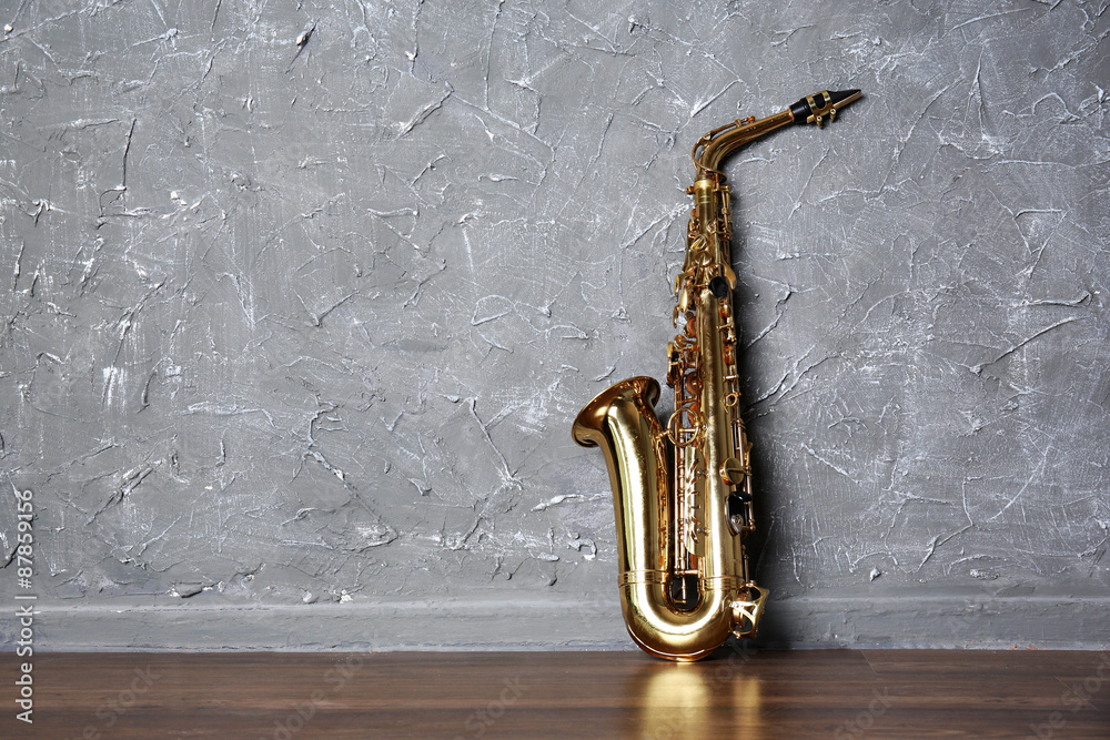 Naklejka premium Golden saxophone on gray wall background