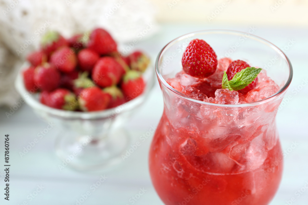 Strawberry dessert with ice in glass, on wooden table, on light background Strawberry dessert with ice in glass, on wooden table, on light background
