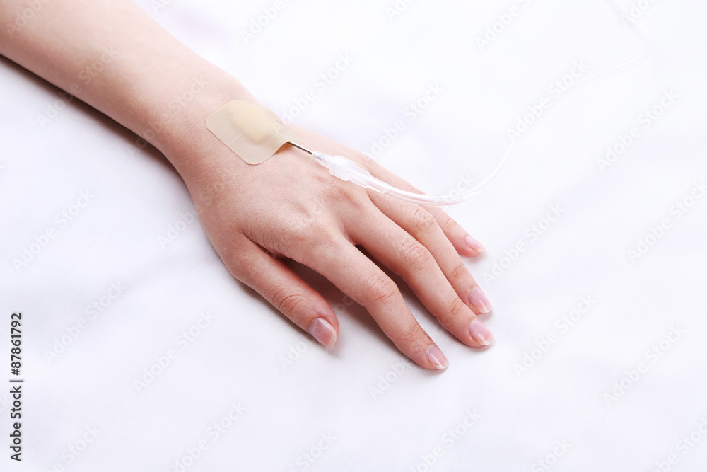 Woman hand with dropper needle on bed close-up
