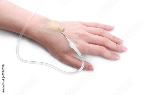 Woman hand with dropper needle on bed close-up