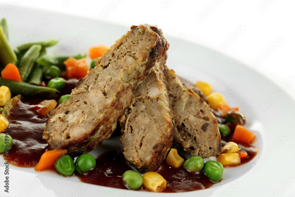 Tasty slices of meat with vegetables on plate close up