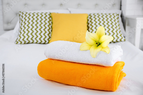 Freshly laundered fluffy towels in bedroom interior