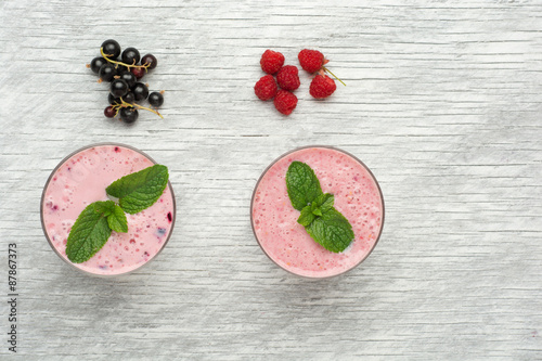 Fresh milk, currant, raspberry and red currant drinks on wodeen photo