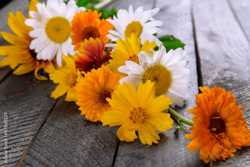 Bright wildflowers on wooden table  closeup