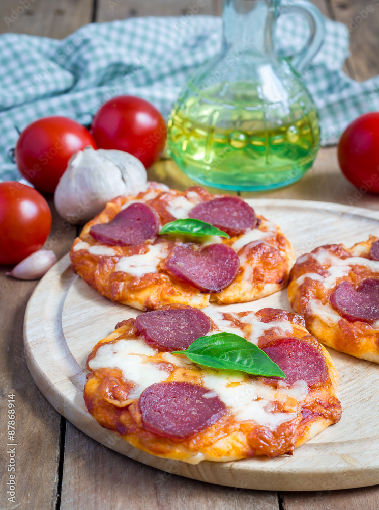 Homemade mini pepperoni pizza on a wooden board Homemade mini pepperoni pizza on a wooden board