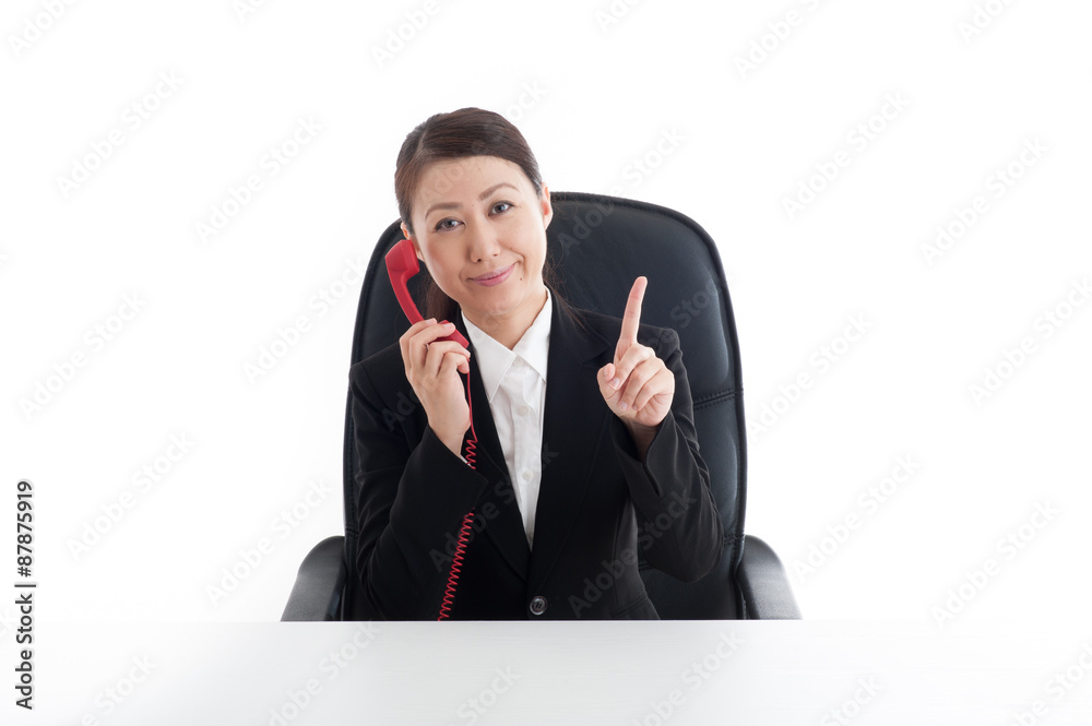 電話をかけている女性社員 電話をかけている女性社員