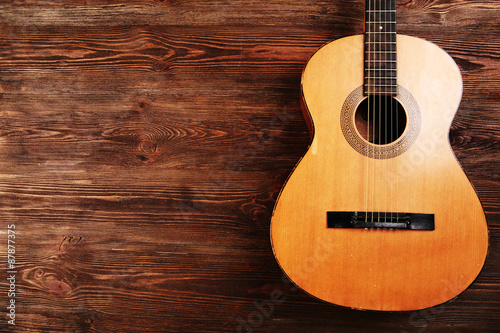 Acoustic guitar on wooden background