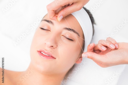 Hands threading beautiful womans upper lip