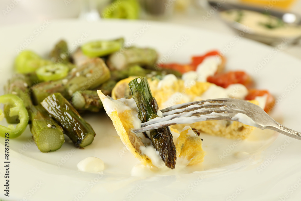 Roasted asparagus with fried egg on plate on table, close-up