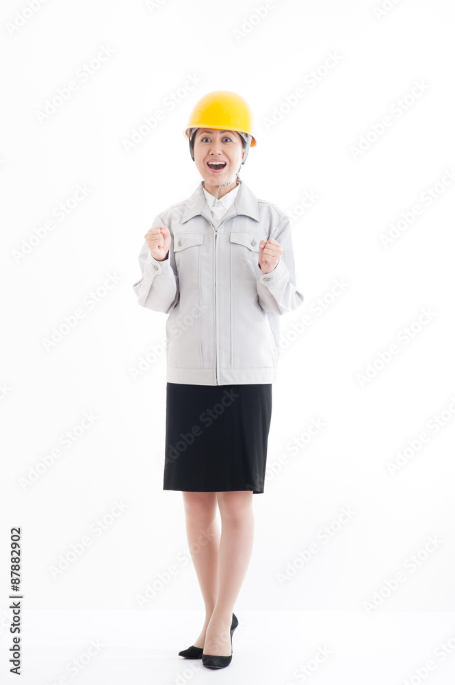 ヘルメットを被っている作業服の女性,ガッツポーズ