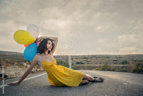 Woman in a yellow dress lying on the street photo