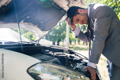 Принти на полотні Man looking under the hood of car