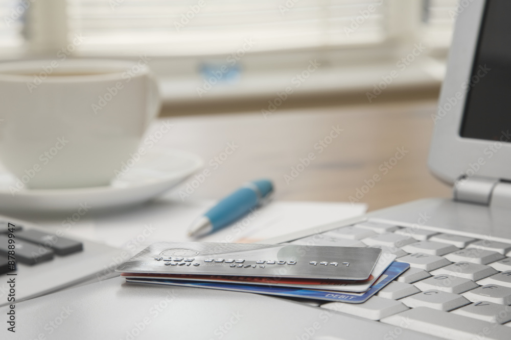 credit cards on a laptop with credit card statements credit cards on a laptop with credit card statements