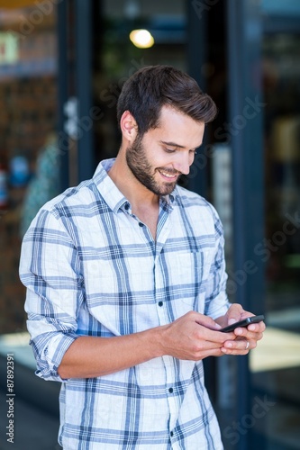 Hipster man using his smartphone in the city