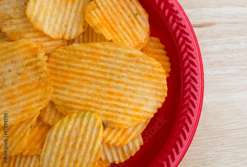 Cheddar cheese potato chips on red plate