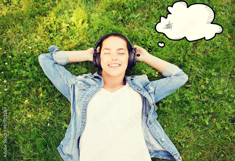 smiling young girl in headphones lying on grass smiling young girl in headphones lying on grass