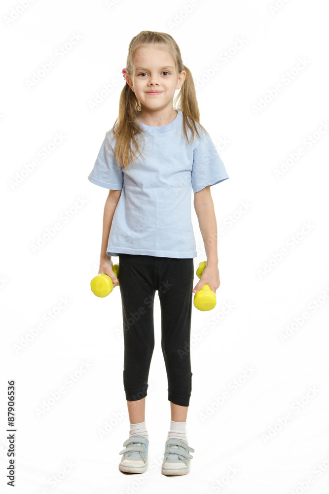 Six year old girl athlete standing with dumbbells Six year old girl athlete standing with dumbbells