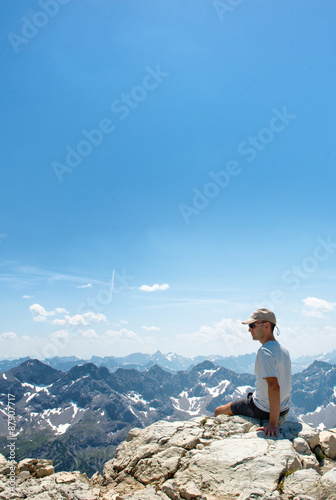 Rear view of hiker at the top of a rock or summit