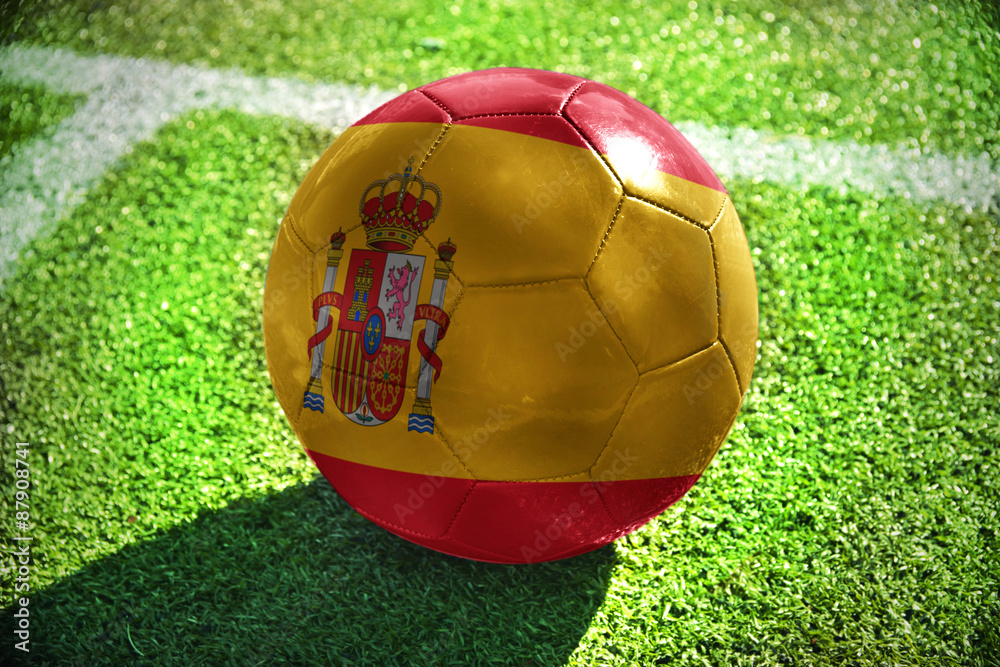 Ταπετσαρία football ball with the national flag of spain lies on the green field near the w