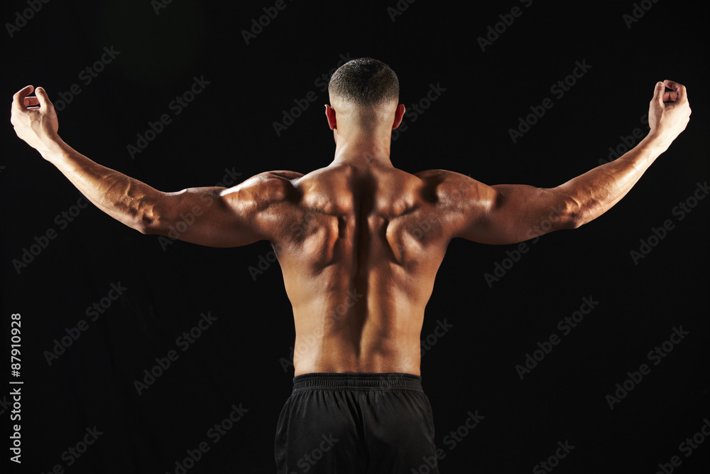 Male bodybuilder flexing muscles, back view
