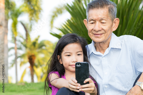 Grandfather and grandchild making selfie with smart phone in the © comzeal