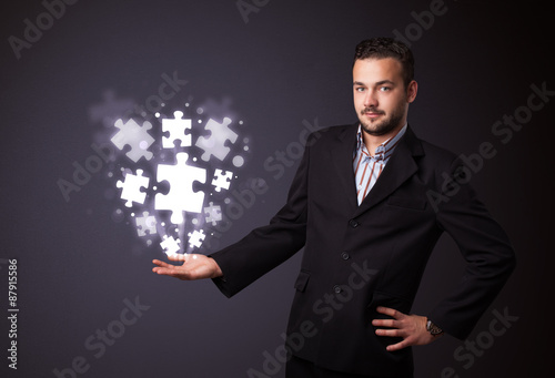 Fototapeta Naklejka Na Ścianę i Meble -  Puzzle pieces in the hand of a businessman