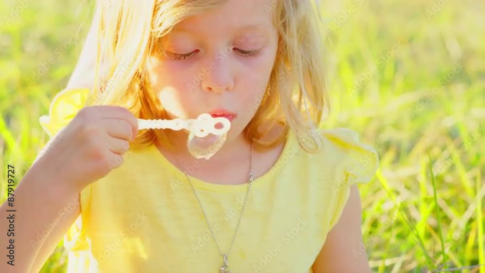 Young blonde girl blowing bubbles outside Young blonde girl blowing bubbles outside