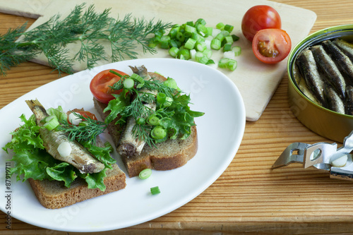 sprats, bread, onion and tomatoes on a table