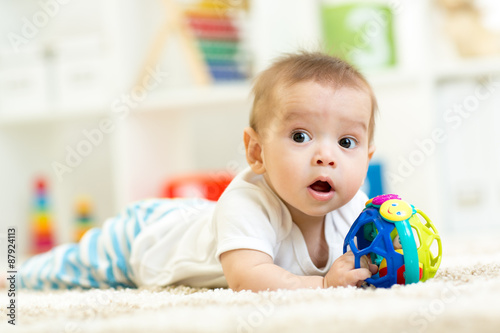 baby playing on a carpet at home