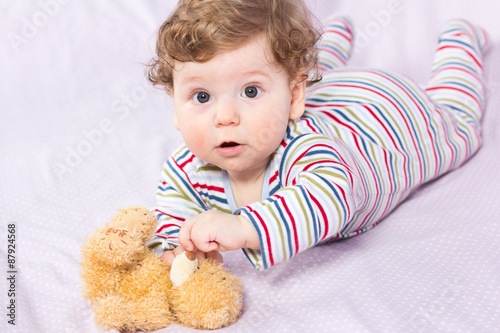 Beautiful baby with a lovely toy. The child in the crib. 