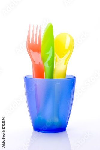 Colorful plastic cutlery in cup