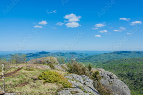 Summit view from atop Sleeping Beauty Mountain in the springtime. Sunshine and blue sky with fair weather clouds complete the scene.