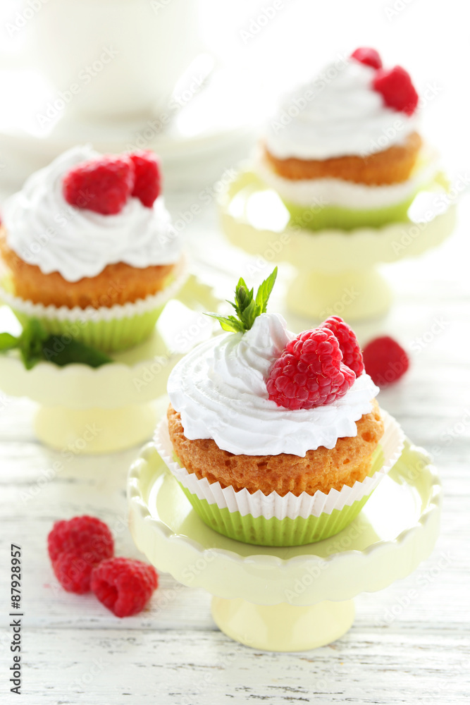 Raspberry cupcakes on cake stand on white wooden background Raspberry cupcakes on cake stand on white wooden background