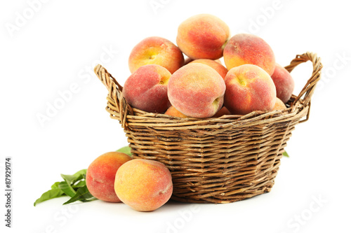 Fresh peach fruit in basket isolated on a white