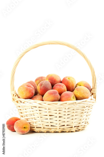 Fresh peach fruit in basket on a white background