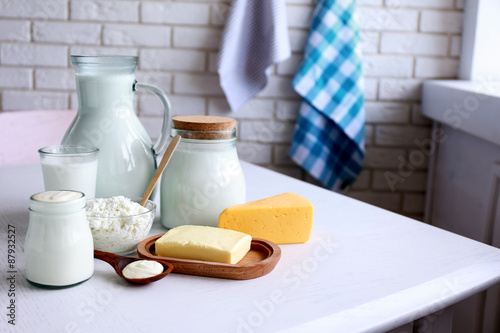 Dairy products on wooden table  on brick wall background