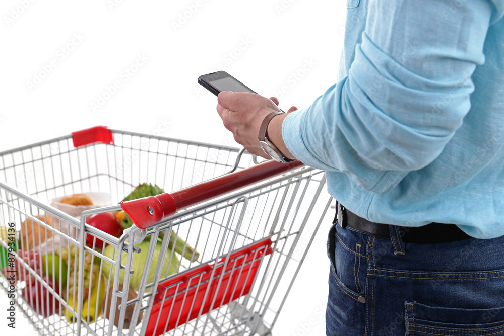 Young man holding mobile phone and shopping cart close up