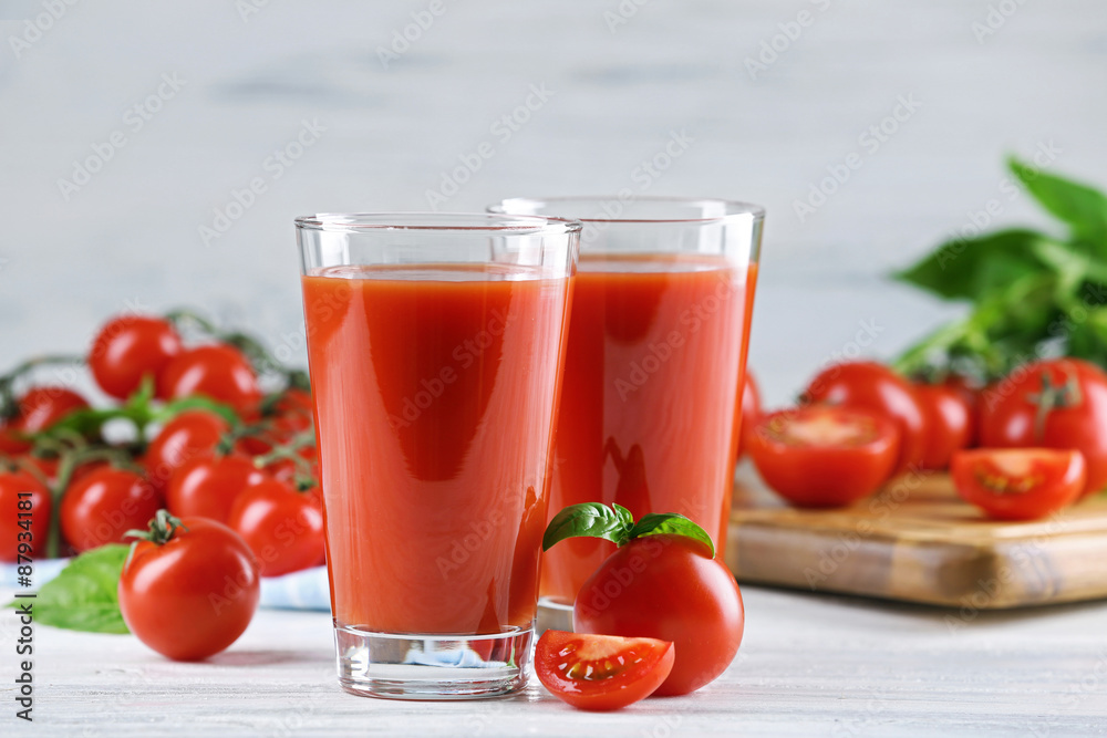 Glasses of tomato juice with vegetables on wooden table close up Glasses of tomato juice with vegetables on wooden table close up