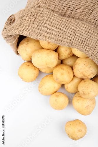 New potatoes in sackcloth bag isolated on white