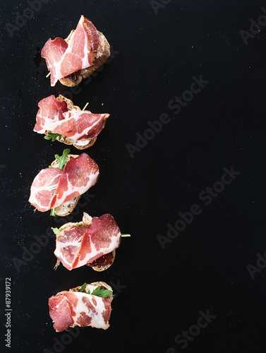 Bruschettas with prosciutto smoked meat, dried tomatoes and