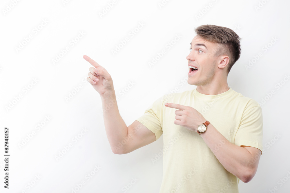 Cheerful man pointing aside on isolated background Cheerful man pointing aside on isolated background