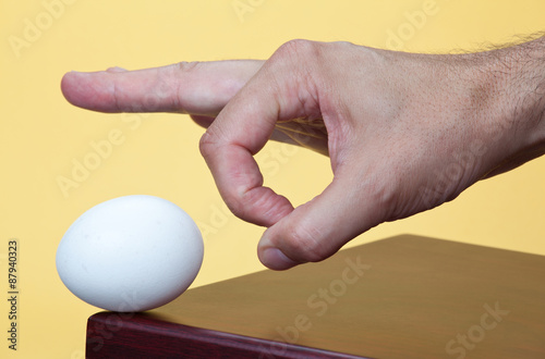 Hand about to flick an egg