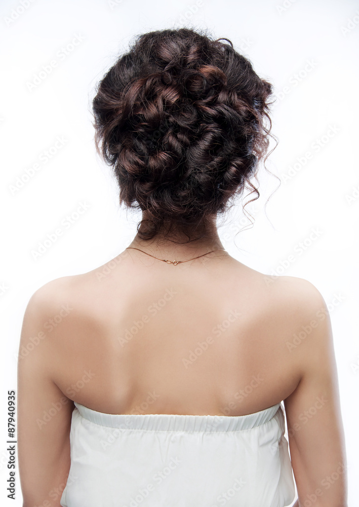 Brunette with an evening hairstyle. View from the back. Brunette with an evening hairstyle. View from the back.